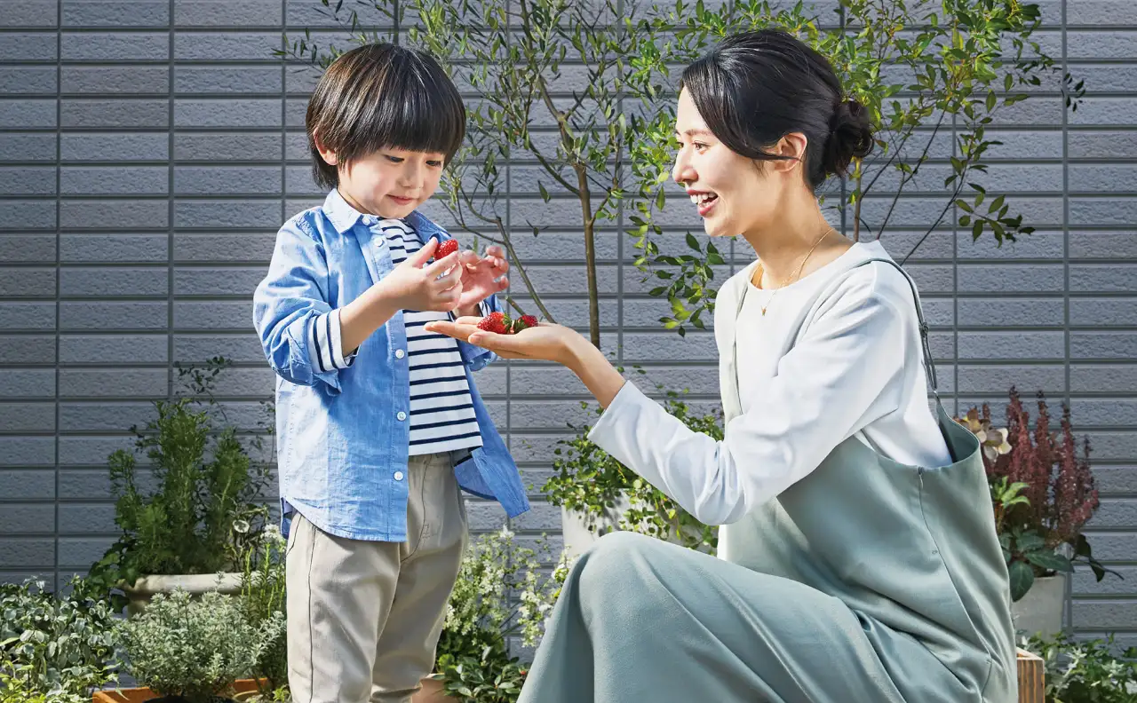 屋上菜園で収穫する母と子